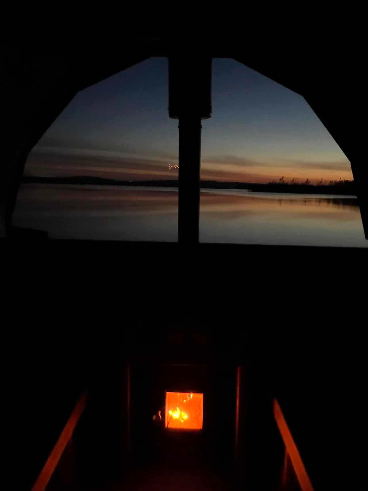The wood stove glows beneath the last colours of sunset