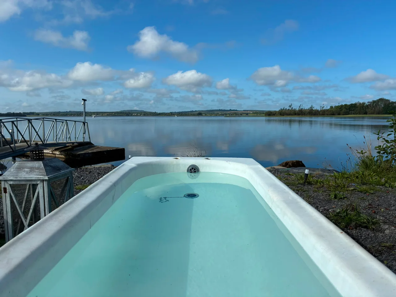 A blue plunge bath filled with clear water beside the harbour