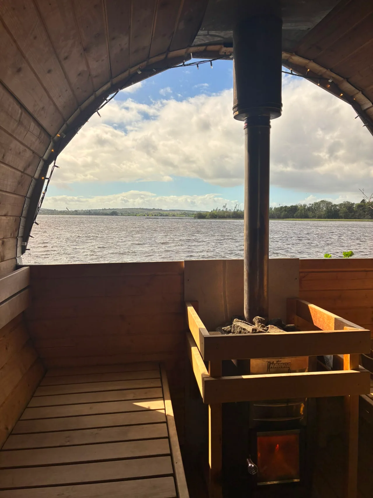 Sunshine falls on the sauna benches beside the wood-burning stove